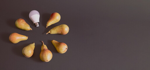 Light bulb and pears in a circle on a black background