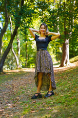 Posing of a young brunette woman in nature walking through the natural park in autumn