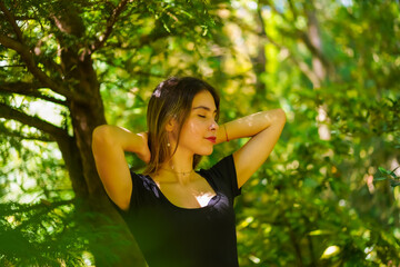 A young brunette woman in nature in the natural park, freedom, dreaming with closed eyes