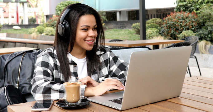 Photo portrait of gorgeous attractive woman working on laptop typing sitting in cafe drinking coffee
