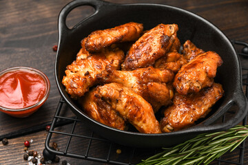 Spicy chicken wings with potatoes fries and ketchup. 