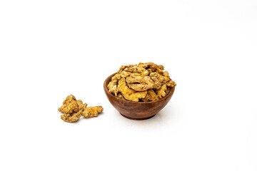 Dry ginger slices or zingiber officinale in bowl isolated on white background