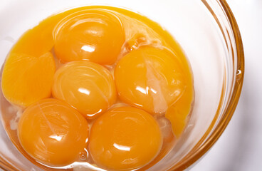 Egg yolks with whites in a glass bowl. Preparation of ingredients for baking a cake. Broken chicken eggs.