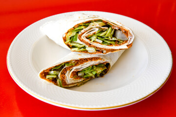 Cig kofte (raw meatball) with lettuce, tomato, pickle and lemon, hot Chee kofta. Turkish local raw food concept.Table scene of assorted take out or delivery foods. Doritoslu cig kofte durum.