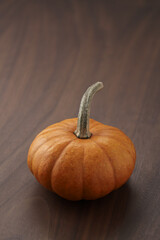 Cute orange pumpkin on wood table with copy space