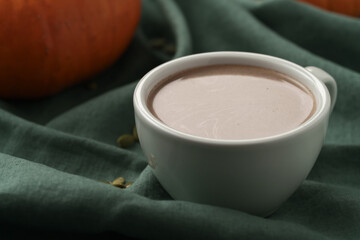 Spiced chcolate drink with pumpkins on background