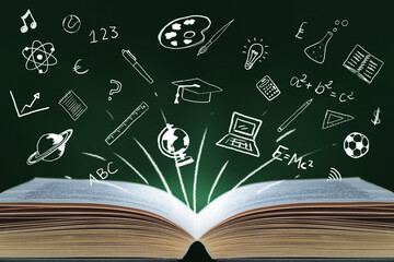 Education and learning concept image. Large open book with icons and symbols of learning tools flying off the open pages. Drawn and illustrated images set against a dark green chalkboard background