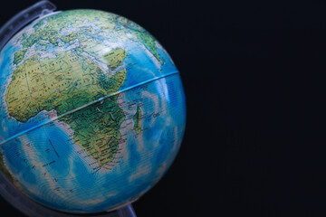 World globe set against a dark black board background. Concept image with copy space available.