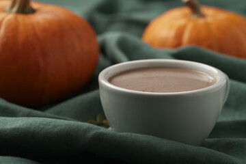 Spiced chcolate drink with pumpkins on background