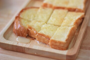 Toast with sweetened condensed milk sprinkle with sugar Place on a brown wooden tray.