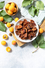 Dried fruits or candied fruit. Dried apricots and raw apricots on a gray stone background. View from above. Copy space.