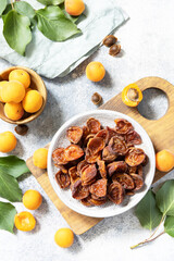Dried fruits. Dried apricots and raw apricots on a gray stone background. View from above.