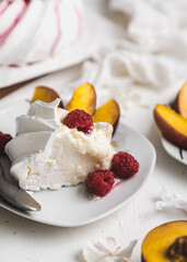 sweet dessert Pavlova cake with raspberries and cream peach