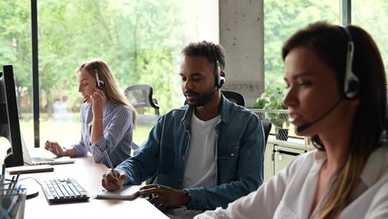 Male representative call center agent in wireless headset helping client, operator working in customer support service