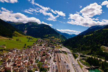 Aerial view of mountain village Airolo, Canton Ticino, with Gotthard highway and Ticino River on a blue cloudy summer day. Photo taken June 25th, 2022, Gotthard Pass, Switzerland.