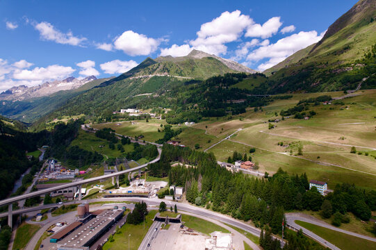 Aerial view of mountain village Airolo, Canton Ticino, with portal of Gotthard road tunnel on a blue cloudy summer day. Photo taken June 25th, 2022, Gotthard Pass, Switzerland.