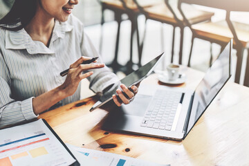 Portrait of an Asian female employee using a tablet computer at work.