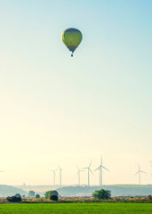 Globo aerostático volando sobre una instalación de aerogeneradores eólicos en Cadiz