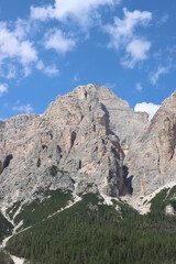 Coravara, Italy-July 16, 2022: The italian Dolomites behind the small village of Corvara in summer days with beaitiful blue sky in the background. Green nature in the middle of the rocks.