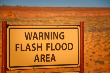 A warning sign for flash floods in a dry riverbed near Antelope Canyon in Page, Arizona