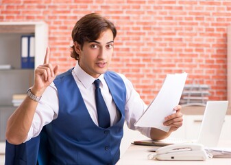 Young handsome employee working in the office