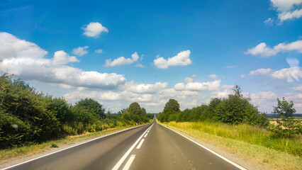 Fototapeta premium Asphalt road at the summer time. Blue sky with clouds. Travel and transportation concept background