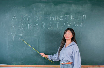 Portrait attractive of smiling Asian Teacher woman teaching student in english classroom, Female teacher writing on blackboard, High school and back to school concept.