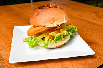 Big tasty burger with beef cutlet on a plate. Crispy chicken burger.