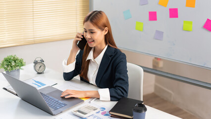 Concept of modern girl leadership, Businesswoman talking on smartphone as looking at data on laptop