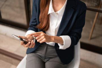 Concept of modern girl leadership, Businesswoman uses her smartphone to relax after hard work