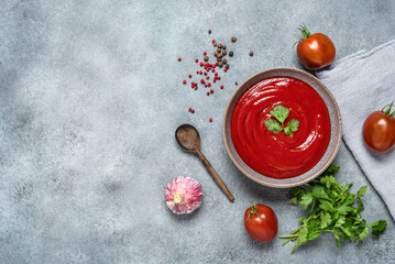Homemade tomato sauce in a bowl, gray concrete grunge background. Top view, flat lay.