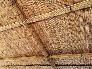 Bastmatten und Korbgeflecht in Beige und Naturfarben als Dach einer Hütte im Sommer am Strand in...