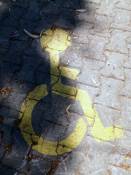 Parkplatz für Rollstuhlfahrer gelb markiert auf grauem Verbundpflaster im Sonnenschein am Strand von Ayvalik in der Provinz Balikesir am Ägäischen Meer in der Türkei
