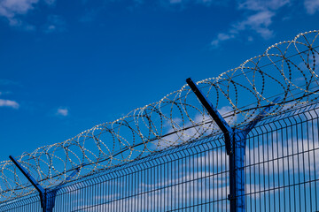 barbed wire fence against the blue sky