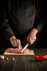 Cook cuts raw beef meat on a cutting board before baking. Asian cuisine. Hotel menu recipe idea
