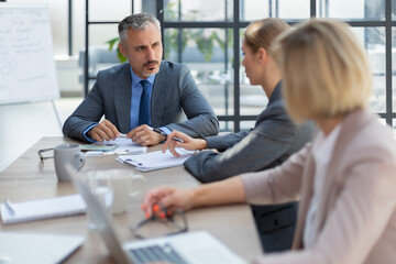 Business team discussing together business plans in office.
