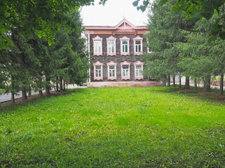green lawn, green trees, old wooden brown house
