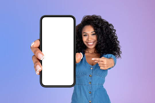 African Woman Pointing At Big Phone With Empty Screen, Purple Background