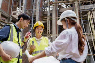 Structural engineer and architect discussing and working with blueprints at the outdoors construction site