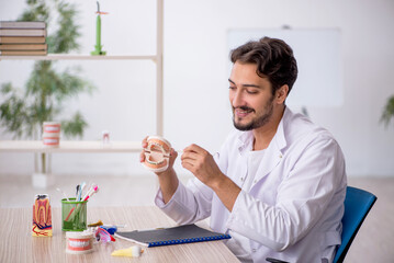 Young male dentist working in the clinic