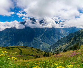 View of huge mountains with waterfalls and beautiful clouds in North Ossetia.