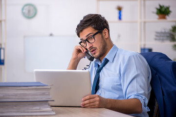 Young businessman employee and too much work in the office