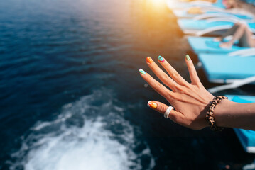 Women beautiful manicure in the pool. Close up
