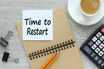 TIME TO RESTART notepad on a wooden background near a cup of coffee