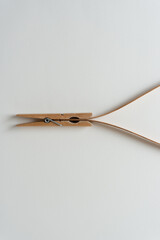 clothespin holding wooden object on blank paper