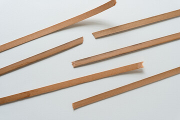 broken pieces of vintage cedar wood straps on blank paper