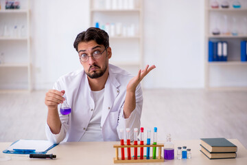 Young male chemist working at the lab