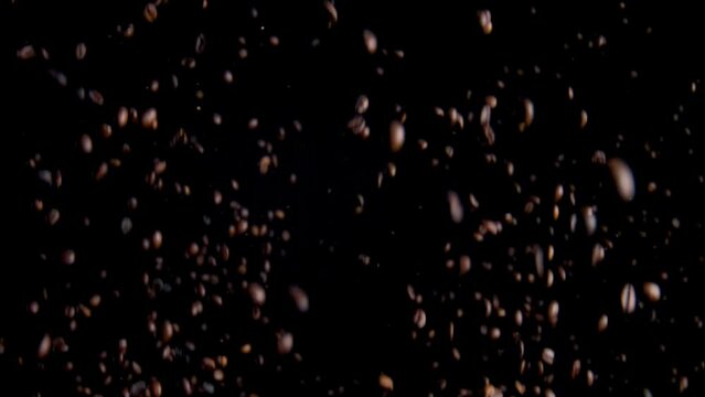 Magic flying coffee beans on black background. Beautiful view arabica grains.