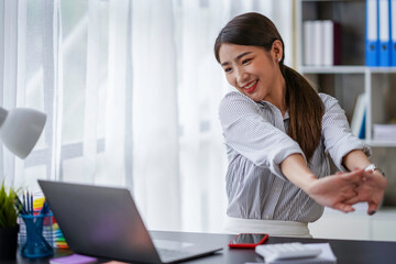 Attractive Asian business woman Relax from work after sitting for a long time. in order not to exceed the office syndrome at the office