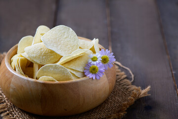 Potato chips bowl on  wood background, fat food or junk food